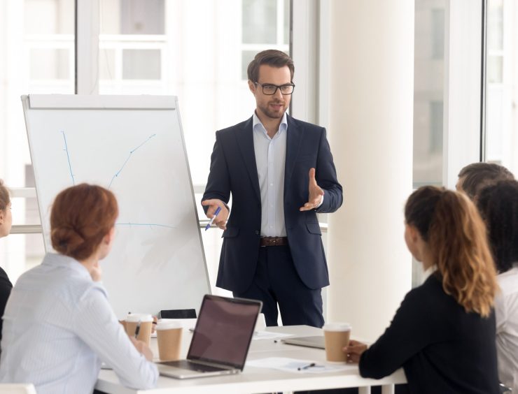 Male,Business,Coach,Speaker,In,Suit,Give,Flipchart,Presentation,,Speaker